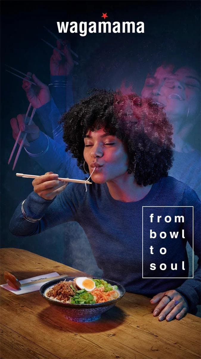 woman with afro eating noodles from a bowl
